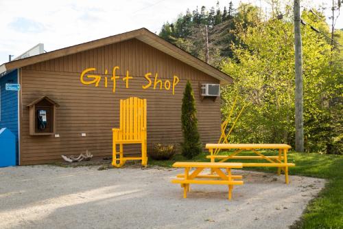 a building with two benches and a gift shop at Middle Brook Cottages & Chalets in Glenburnie
