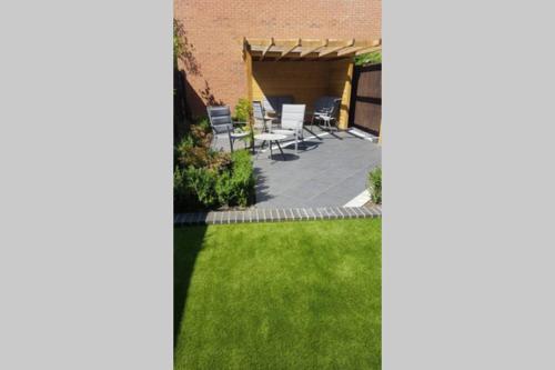 a yard with a patio with chairs and grass at Rutland View in Oakham