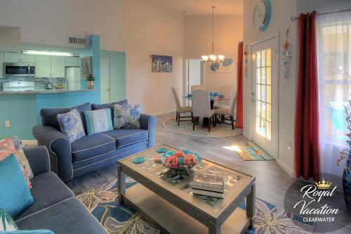 a living room with a blue couch and a table at Royal Dream at Avalon Clearwater - Pool & Free Parking - 10 Min Drive to Clearwater Beach in Clearwater Beach