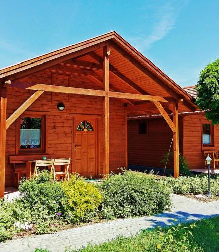 a log cabin with a wooden door and a table at Dream Horse Apartman Cserkeszőlő in Cserkeszőlő