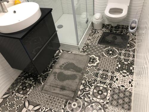 a bathroom with a black and white tile floor with a toilet and sink at Apartment Augsburg Mitte in Augsburg