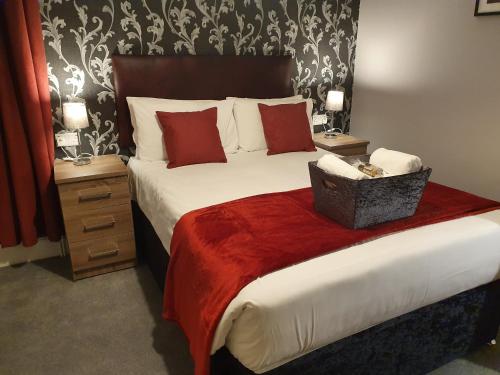 a bedroom with a large bed with red pillows at The Braemar Southport in Southport