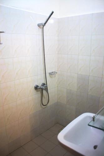 a shower in a bathroom with a tub and a sink at Hôtel Résidence Madiba in Lomé