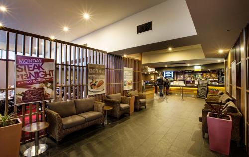 a lobby with couches and chairs in a restaurant at Nightcap at Keysborough Hotel in Keysborough