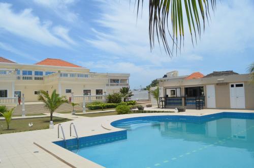 a swimming pool in front of a house at Hôtel Résidence Madiba in Lomé