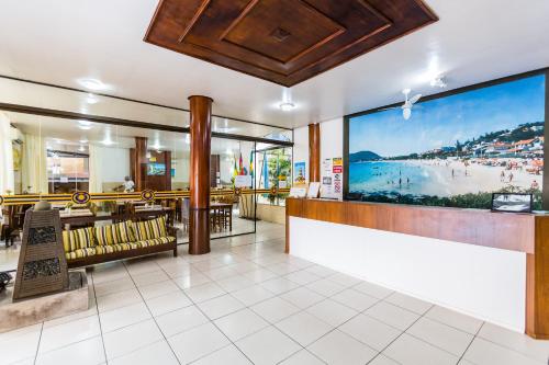 a restaurant with a large picture of the beach at HsHotelaria - Filial Bombinhas in Bombinhas