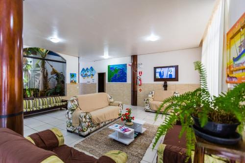 a living room with two chairs and a couch at HsHotelaria - Filial Bombinhas in Bombinhas