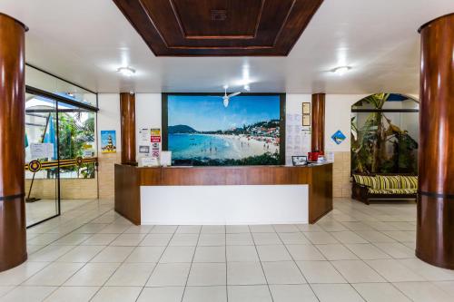 a lobby with a reception desk and a large window at HsHotelaria - Filial Bombinhas in Bombinhas