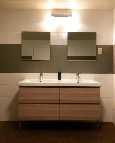 a bathroom with a sink and two mirrors at Maison Flo in Houffalize