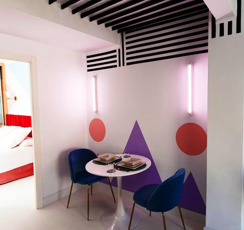 Cette chambre comprend une petite table et des chaises. dans l'établissement Memphis design apartment, à Séville