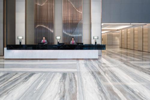 a lobby with two women sitting at a reception desk at Crowne Plaza Hangzhou Qiantang - The subway can reach the West Lake scenic area as well as the airport and high-speed rail station, adjacent to Jinsha Lake and Longfor paradise walk in Hangzhou