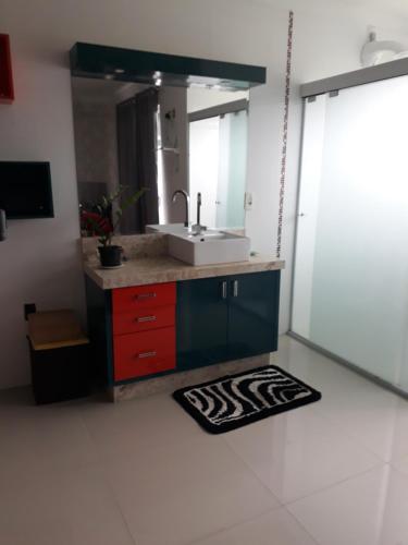 ein Badezimmer mit Waschbecken und Spiegel in der Unterkunft Residencial helena cobertura in Bombinhas