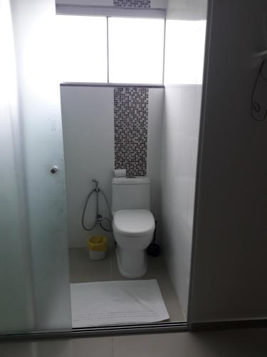 uma casa de banho com um WC branco num quarto em Residencial helena cobertura em Bombinhas