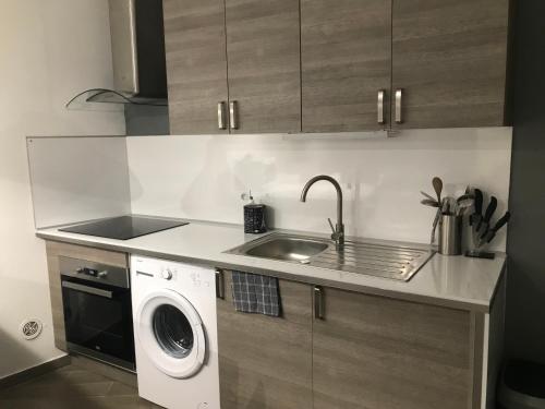 a kitchen with a sink and a washing machine at Studio Centre ville Castellane in Castellane
