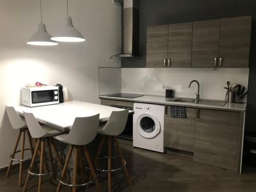 a kitchen with a table with a microwave and a washing machine at Studio Centre ville Castellane in Castellane