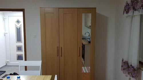 a wooden cabinet in a room with a table at Apartment Centar in Kočani