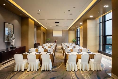 a room with rows of tables and white chairs at Crowne Plaza Hefei Rongqiao by IHG in Hefei