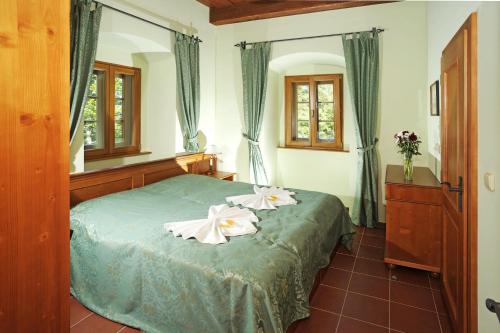 a bedroom with a bed with two flowers on it at Hotel Kristin Hrádek in Děčín