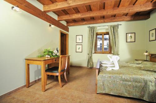 a bedroom with a desk and a bed and a table at Hotel Kristin Hrádek in Děčín