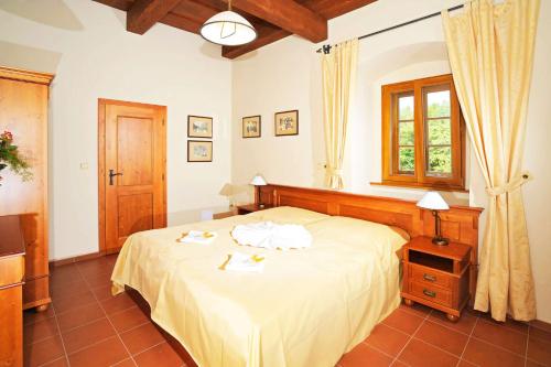a bedroom with a bed with two towels on it at Hotel Kristin Hrádek in Děčín