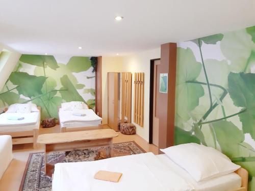 a bedroom with two beds and a green wall at Penzion Havaj in Karlovy Vary