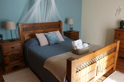 a bedroom with a large wooden bed with pillows at Monte das Pedras in Abrantes
