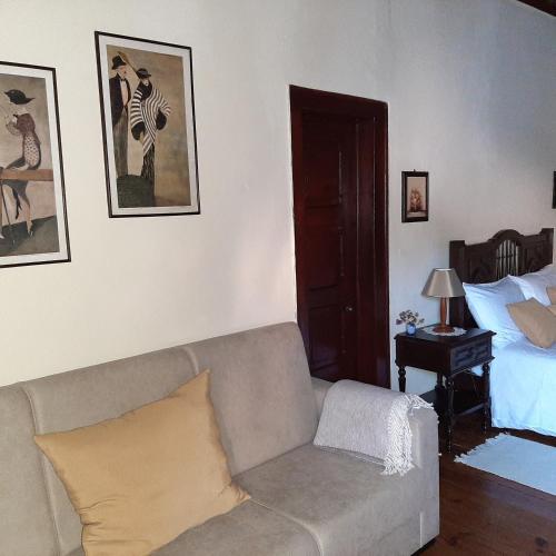a living room with a couch and a bed at Casa do Sr. Falcão in Miranda do Corvo