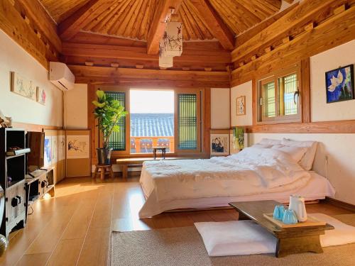a bedroom with a large bed and a wooden ceiling at Siwoowadang in Gyeongju