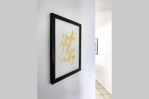 a framed picture on a white wall with a black frame at Executive and Family Home Large - Flinders View 24 in Ipswich