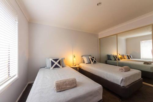 1 dormitorio con 2 camas y espejo en Executive and Family Home Large - Flinders View 24, en Ipswich