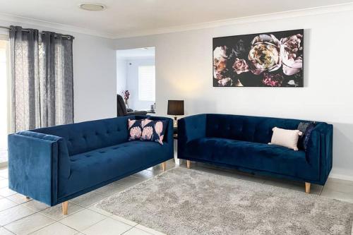 two blue couches sitting in a living room at Executive and Family Home Large - Flinders View 24 in Ipswich