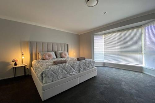 a bedroom with a large bed and a window at Executive and Family Home Large - Flinders View 24 in Ipswich