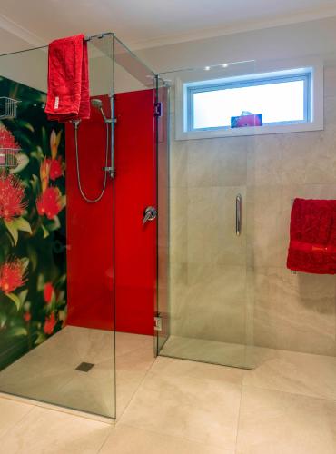 a bathroom with a shower with a red door at Ribbonwood Country House in Cheviot