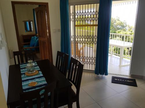 a dining room with a table and chairs and a balcony at Chepsted Chalets in Glacis