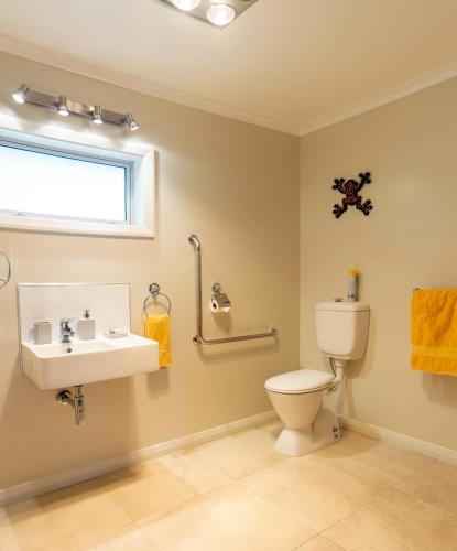 a bathroom with a toilet and a sink and a window at Ribbonwood Country House in Cheviot