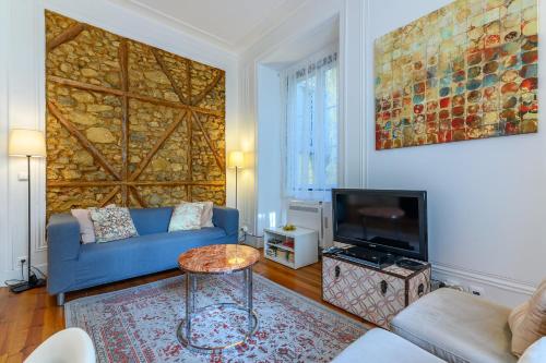a living room with a blue couch and a tv at Localtraveling Historic Center Travessa in Lisbon
