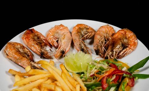 a plate of food with shrimp and french fries at Sea View Villa Ukulhas in Ukulhas