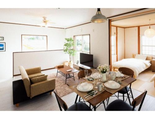 a living room with a table and a bed at ANJIN Stay Awaji - Resort villa with ocean view & BBQ - Self Check-In Only in Akashi