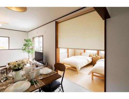 ein Wohnzimmer mit einem Tisch und 2 Betten in der Unterkunft Anjin Stay Awaji - Self Check-In Only in Akashi