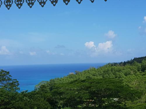 a view of the ocean from a hill with trees at Chepsted Chalets in Glacis