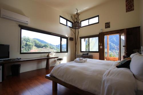 南庄的住宿－ 山行寄野民宿，一间卧室设有一张大床和享有美景的窗户。