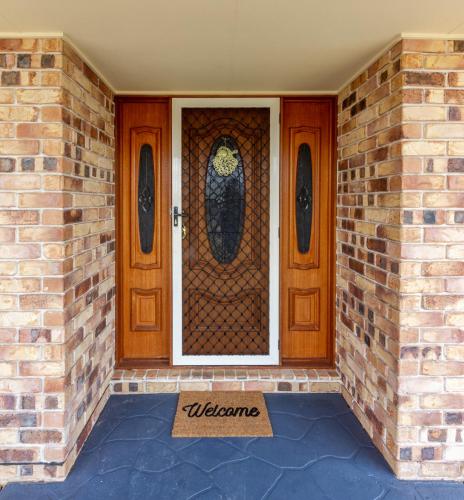 a door with a welcome sign in front of a house at Executive and Family Home Large - Flinders View 24 in Ipswich
