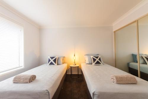 two twin beds in a room with a window at Executive and Family Home Large - Flinders View 24 in Ipswich