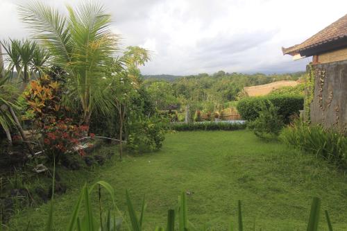 a backyard with a yard with grass and trees at Giri Carik in Sidemen