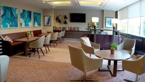 a waiting room with tables and chairs and a tv at Crowne Plaza Harrogate by IHG in Harrogate