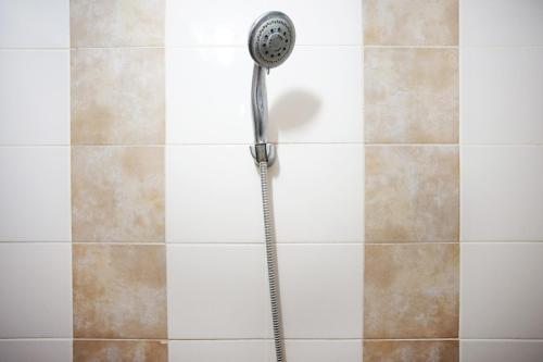 a shower with a shower head in a bathroom at Kamarku Apartment in Cimindi-hilir