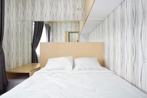 - une chambre avec un grand lit et des draps blancs dans l'établissement Kamarku Apartment, à Cimindi-hilir