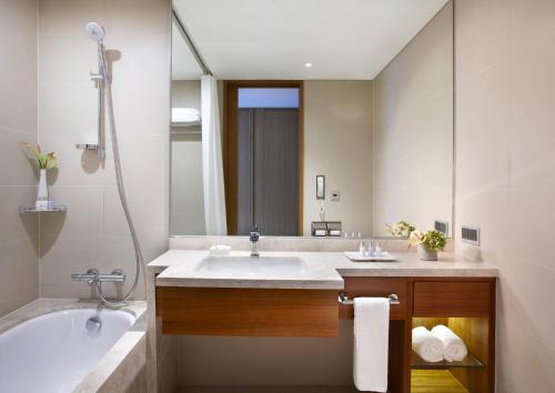 a bathroom with a tub and a sink and a bath tub at LOTTE City Hotel Guro in Seoul