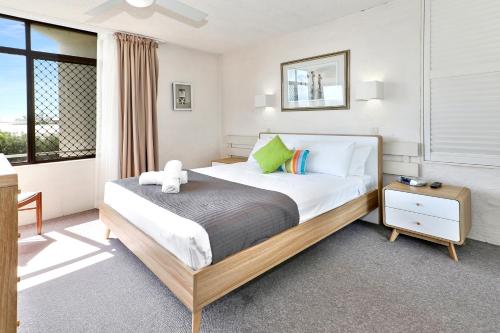 a bedroom with a bed with a teddy bear on it at Warroo Apartments in Alexandra Headland