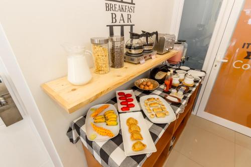 a breakfast bar with plates of food on a counter at Omah Manis in Yogyakarta